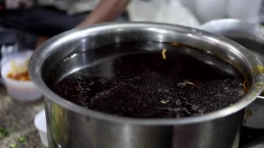 Nihari sosu, körili koyun eti ve güveç için yağ dolu çelik kap..