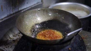 Tibetli anneler ve börekler için Hint tavasında kırmızı turşu sosu pişirmek. Kızarmış soğan, tuzlu ve diğer baharatlarla..