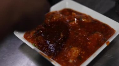 Tavuk soslu momo ya da üzeri soğuk, biberli ve soslu hamur tatlısı..