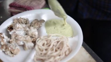 Kağıt tabakta soğan ve nane aromalı Malai tikka tabağı. 