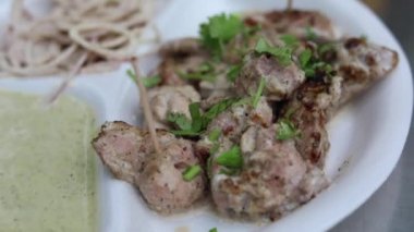 Kağıt tabakta soğan ve nane aromalı Malai tikka tabağı. 