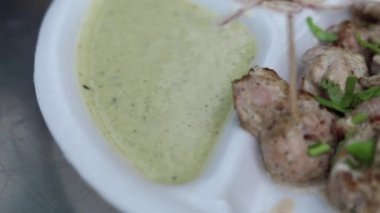 Kağıt tabakta soğan ve nane aromalı Malai tikka tabağı. 
