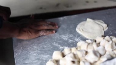 Momo ya da samosa için belan kullanarak Hint ekmeği hamuru yoğurmak..