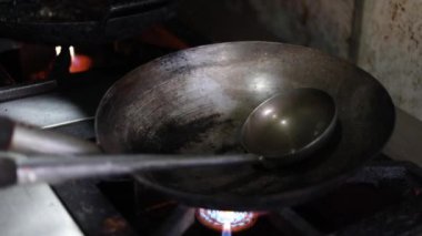 Tibetli anneler ve börekler için Hint tavasında kırmızı turşu sosu pişirmek. Kızarmış soğan, tuzlu ve diğer baharatlarla..