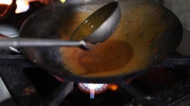Tibetli anneler ve börekler için Hint tavasında kırmızı turşu sosu pişirmek. Kızarmış soğan, tuzlu ve diğer baharatlarla..