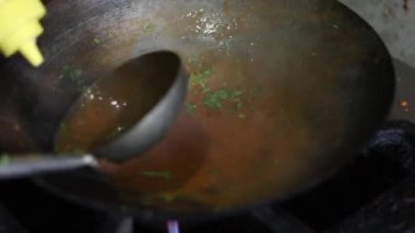 Tibetli anneler ve börekler için Hint tavasında kırmızı turşu sosu pişirmek. Kızarmış soğan, tuzlu ve diğer baharatlarla..