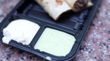 Hint usulü tavuk shawarma 'nın üst görüntüsü. Plastik tabakta mayonez var..