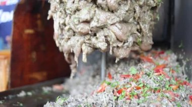 Sokak lokantasında dönen bir shawarma makinesinden tavuk kesmek. Barbeküyü asıyorum.