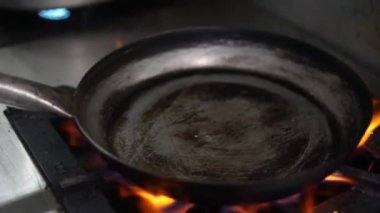 Yağ ve alevlerle dolu bir tavayı tutuşturmak.