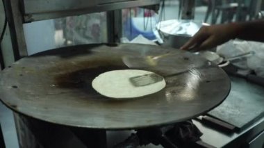 Bir sokak restoranında büyük bir Hint tavasında Hint ekmeği pişirmek.. 