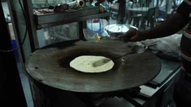 Bir sokak restoranında büyük bir Hint tavasında Hint ekmeği pişirmek.. 