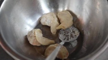 Afgan buğulanmış tavuk momo 'ları krema ve baharatla marine edilmiş soğan, kırmızı baharatlı sos ve yeşil nane sosuyla servis ediliyor..