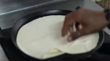 Bir sokak restoranında büyük bir Hint tavasında Hint ekmeği pişirmek.. 