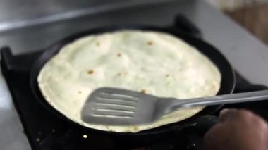 Bir sokak restoranında büyük bir Hint tavasında Hint ekmeği pişirmek.. 