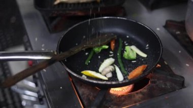 Kırmızı sos, sotelenmiş sebzeler, karamelli soğanlar, kırmızı biberler ve sıcak yağ tavasında kapsiyum..