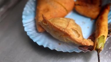 Kızarmış sebzeleri kızartarak Hint usulü börek ya da ekmek pakoda yapmak. Sıcak yağ kadhai içinde marine edilmiş ekmek..