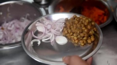 Soğan, kızılderili salatası ve bezelye ile sunulan choley bhature sosu..