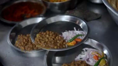Soğan, kızılderili salatası ve bezelye ile sunulan choley bhature sosu..