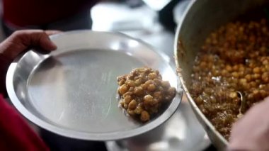 Soğan, kızılderili salatası ve bezelye ile sunulan choley bhature sosu..
