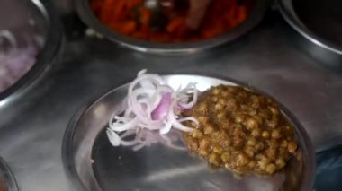 Soğan, kızılderili salatası ve bezelye ile sunulan choley bhature sosu..