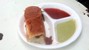 Kızartma tavasında Hint sokak vada pav yeşil turşu, kırmızı domates sosu ve masala ile servis edilir..