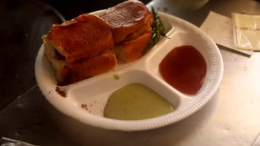 Kızartma tavasında Hint sokak vada pav yeşil turşu, kırmızı domates sosu ve masala ile servis edilir..