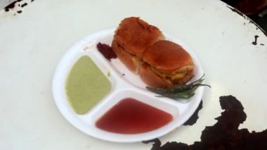 Kızartma tavasında Hint sokak vada pav yeşil turşu, kırmızı domates sosu ve masala ile servis edilir..