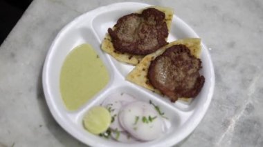 Bir tabak lezzetli koyun eti, galouti kebabı, otantik Hint ekmeği parantha ve baharatıyla servis ediliyor..