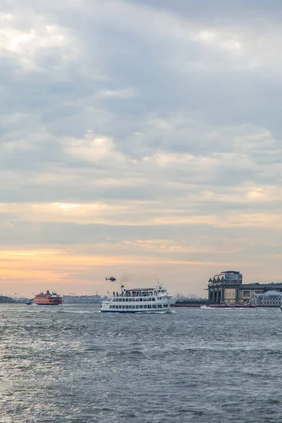 Tekne ya da yat doğu nehrinden geçerek Dimond Resifi 'ne doğru gidiyor. Arkasında da Brooklyn Köprüsü Parkı' ndan vurulan Özgürlük Heykeli var..