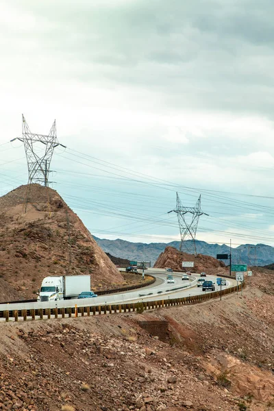 Mojave, Las Vegas, Nevada yakınlarındaki bir çölden geçen beyaz kamyon büyük kablolu kulelerin önünden geçiyor..