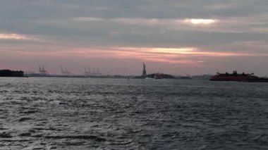 Tekne ya da yat doğu nehrinden geçerek Dimond Resifi 'ne doğru gidiyor. Arkasında da Brooklyn Köprüsü Parkı' ndan vurulan Özgürlük Heykeli var..