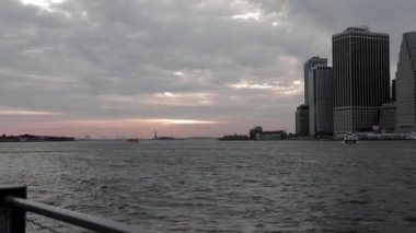 Tekne ya da yat doğu nehrinden geçerek Dimond Resifi 'ne doğru gidiyor. Arkasında da Brooklyn Köprüsü Parkı' ndan vurulan Özgürlük Heykeli var..