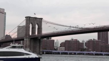 New York şehrinin siluetinin önündeki nehirde yelken açan yat ya da gemi..