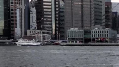 Tekne ya da yat doğu nehrinden geçerek Dimond Resifi 'ne doğru gidiyor. Arkasında da Brooklyn Köprüsü Parkı' ndan vurulan Özgürlük Heykeli var..