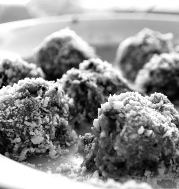 Kurutulmuş meyvelerden yapılan ev yapımı tatlılar ve üzerine hindistan cevizi serpiştirilmiş fıstık ezmesi. siyah ve beyaz