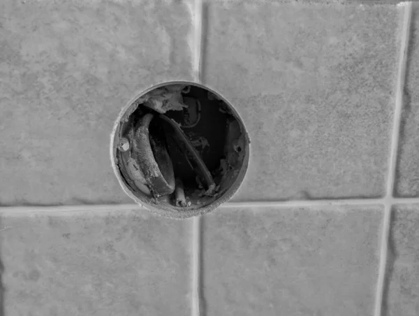installation of an electrical outlet. hole with a wire for the socket in the tile. renovation in the apartment. black and white