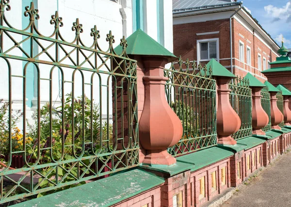 緑の錬鉄製の柵 赤レンガ工場 — ストック写真
