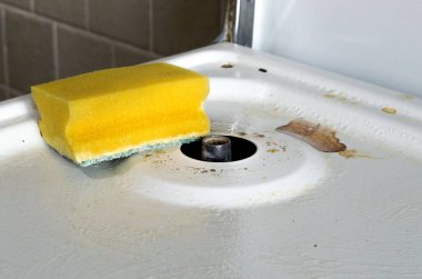 Gaz sobasını temizliyorum. Sarı köpük temizleme süngeri. Tepesi gaz sobasının kirli yüzeyi. Elektrikli ocak olmadan. pan desteği olmadan