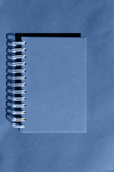 蓝色背景上的弹簧上的蓝色笔记本 有足够的文字空间 — 图库照片