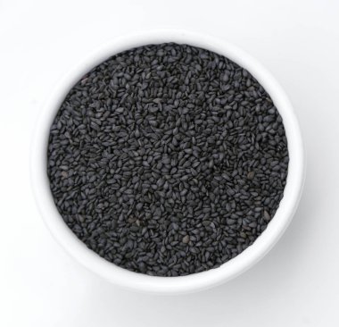 Beyaz arkaplanda izole edilmiş siyah susam tohumları yığını