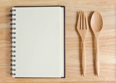 Açık Not defteri ve kaşık çatal ile boş ahşap levha