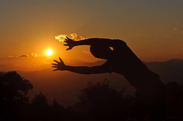 silhouette of man posting with the sunset