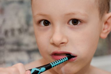 Tatlı çocuk banyoda dişlerini fırçalıyor.