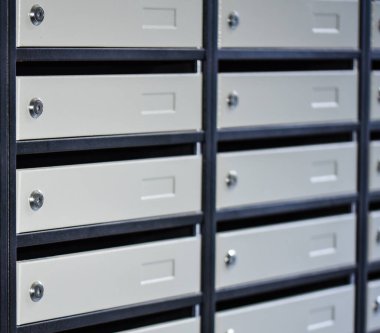 Bir apartmanın girişindeki duvarda kilit olan posta kutuları grisi. Apartman dairesinde posta kutuları gri