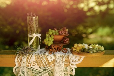 Üzüm, peynir, lavanta çiçek aranjman beyaz masa örtüsü üzerinde