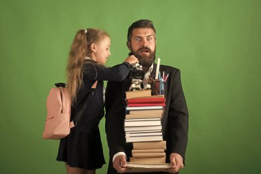 Çocuk ve öğretmen kitap yığın ve okul gereçleri