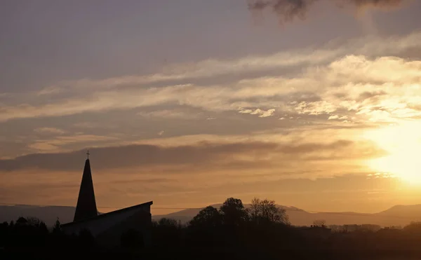 风景和教会, 十字架剪影在多云日落天空 — 图库照片