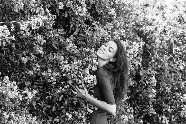 Menina bonita entre flores florescentes — Fotografia de Stock