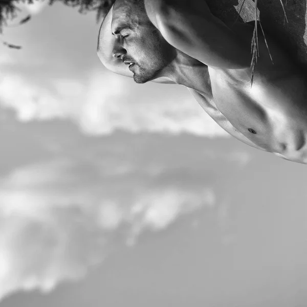 Muskulös man koppla av på himmel bakgrund — Stockfoto