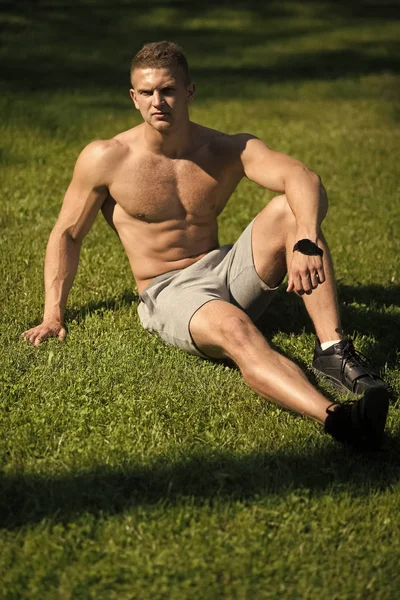 在晴朗的日子, 运动员坐在绿草上 — 图库照片